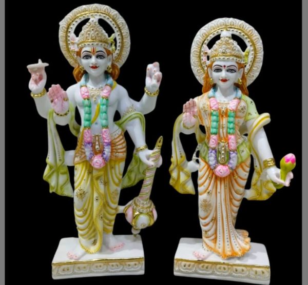 🌟 Exquisite Marble Vishnu and Lakshmi Murti Set by Gatimaan Creation 🌟 Bring divine grace and prosperity into your home with this stunning pair of Hindu deities, Lord Vishnu and Goddess Lakshmi, meticulously crafted by Gatimaan Creation. ✨ Product Highlights Material: Premium quality Stone/Marble, giving the statues a smooth, luminous white finish with delicate veining. Craftsmanship: Expertly hand-painted with vibrant, yet subtle colors in shades of yellow, green, pink, and orange, accented with intricate gold detailing and sparkling embellishments. Deities: Lord Vishnu: Depicted in a standing posture, holding his traditional attributes, the Conch (Shankha) and a Mace (Gada). His upper right hand is raised in a gesture of blessing (Abhaya Mudra). Goddess Lakshmi: Standing beside her consort, holding a Lotus (Kamala) in her hand, signifying purity and beauty. Her left hand is raised in a gesture of fearlessness and assurance. Aura & Detail: Both statues feature beautifully carved Kiritamukuta (crowns) and circular Halos behind their heads, highlighting their divine presence. They are adorned with colorful garlands and necklaces. Base: Each statue stands firmly on a square, white base with elegant gold trim. Dimensions: Perfect for placement in your home temple (Mandir), altar, or as a magnificent centerpiece for your living space. 💖 Why Choose This Set? This magnificent Vishnu-Lakshmi Murti Set is more than just a decorative piece; it is a symbol of harmony, wealth, good fortune, and cosmic balance. Lord Vishnu is the preserver of the universe, and Goddess Lakshmi is the giver of spiritual and material prosperity. Ideal for: Pooja ceremonies, housewarming gifts (Griha Pravesh), weddings, festivals (Diwali, Janmashtami), or as an exceptional collector's item. Artist: Proudly made by Gatimaan Creation, a name synonymous with fine, high-quality spiritual artistry.
